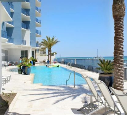 Beach level pool deck with heated infinity pool and hot tub.