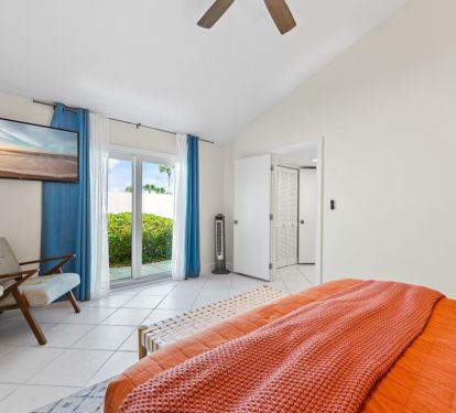 This spacious en suite bedroom features warm coastal tones, cozy textures, and a private bathroom&mdash;perfect for guests who prefer no stairs and easy access to everything.