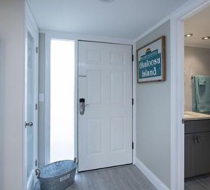 The entrance to the condo shows the first bathroom and the kitchen is nearby. 