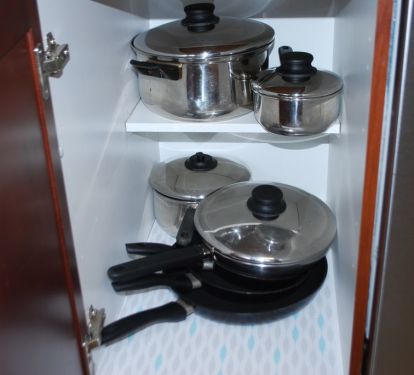 kitchen fulling stocked with pots , pans , dishes , utensils. etc.