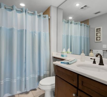 Guest Bathroom Has A Tub / Shower Combo and white quartz countertops