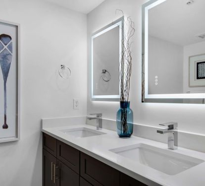Dual sinks and lighted mirrors in primary bath. 