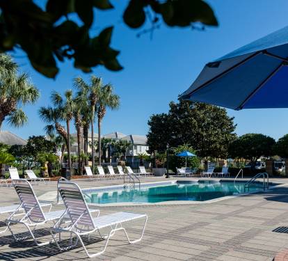 One of two pools offered with large sundeck, tables with umbrellas, bathrooms