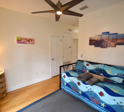 Second floor sitting room with twin daybed, pop-up trundle, and balcony access