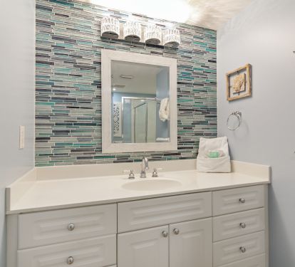 A new glass tile accent wall and crystal light make the guest bath sparkle!