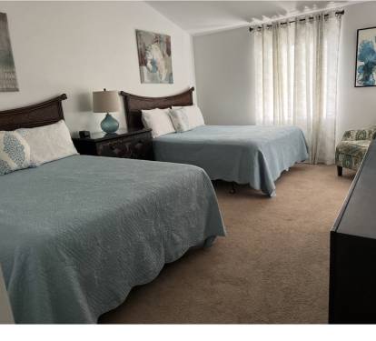 Upstairs bedroom with 2 queen beds and a private balcony 