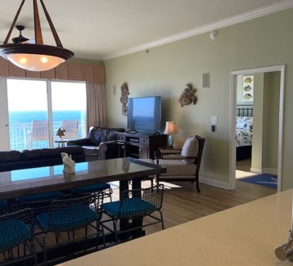 Kitchen with bar seating that opens up to dining area and den