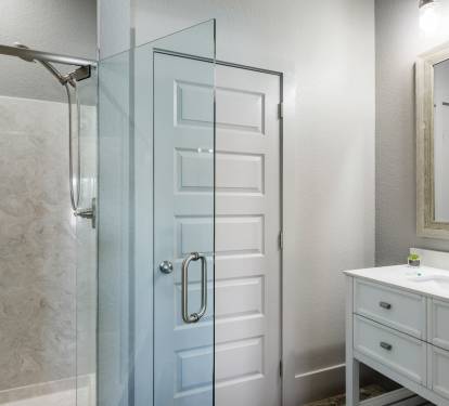 Private bathroom has glassed in shower