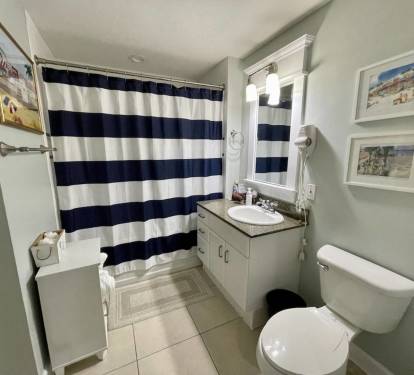 Bathroom with tub and shower, opens to hallway and second bedroom