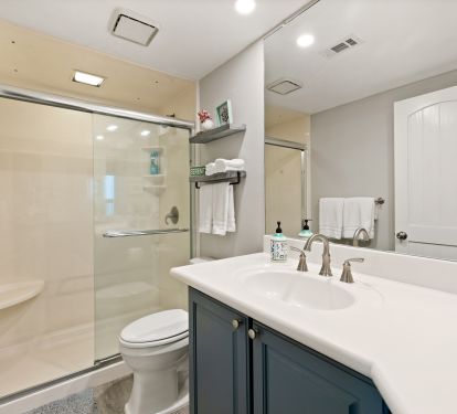 Primary bath has walk in shower and a cool coastal vibe.