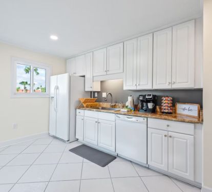 The Seabreeze Villa kitchen is bright and welcoming, featuring crisp white cabinets, marble-inspired countertops, and gold accents. Equipped with modern essentials, including a coffee station to start your mornings right. â˜•âœ¨