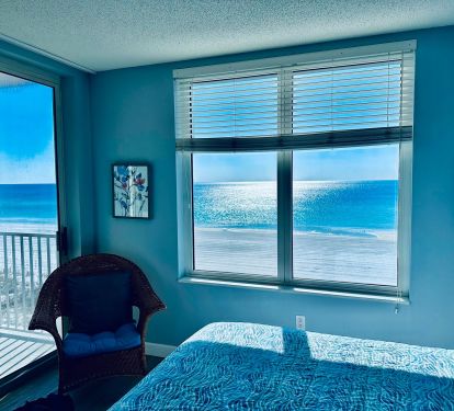 Master bedroom with king bed and private access to balcony.