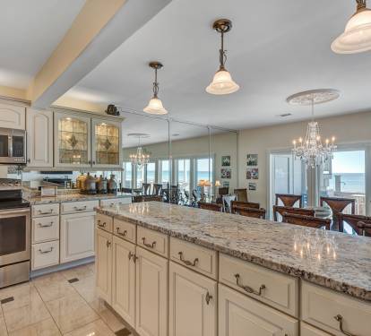 Kitchen and Dining Room with Ocean Viewed out of Floor-to-Ceiling Windows 