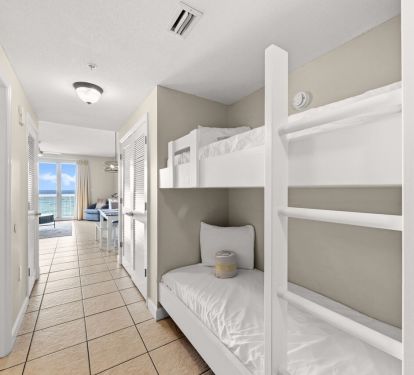 Hallway bunk beds with coastal views leading to bright oceanfront living area