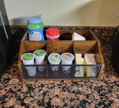Coffee bar with assorted K-cups, sugar, sweetener, filters and creamer.