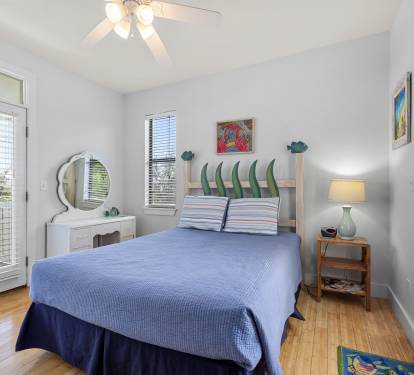 Queen bed in upper level bedroom with balcony access