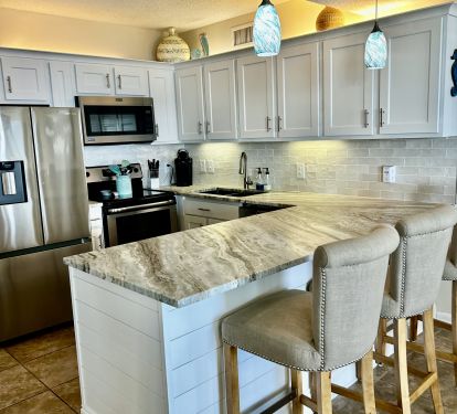 Kitchen with newly remodeled cabinets and granite counters. Bar seats 3.