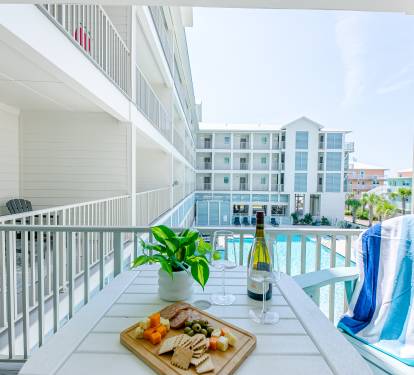 Large balcony with table and chairs, and a glider chair