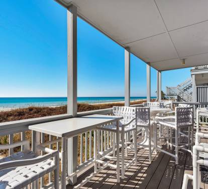 Deck that is Adjacent with the Beach and Ocean and has Seating for 10 Guests and Tables