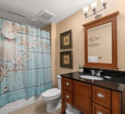 Another bathroom with vanity, hair dryer, and bath tub.