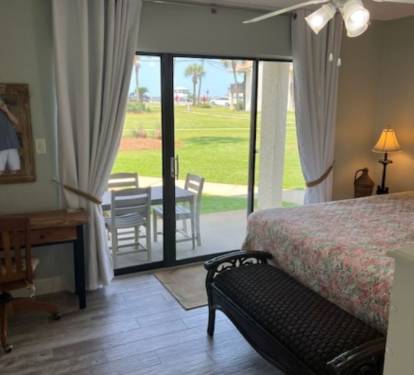 Downstairs bedroom opens up to patio with table and chairs for al fresco dining