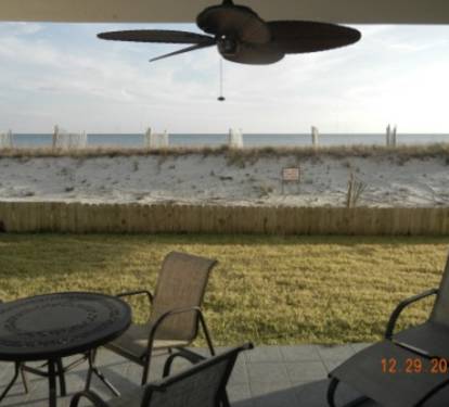 Patio w/table &amp; chairs; grassy area before dune