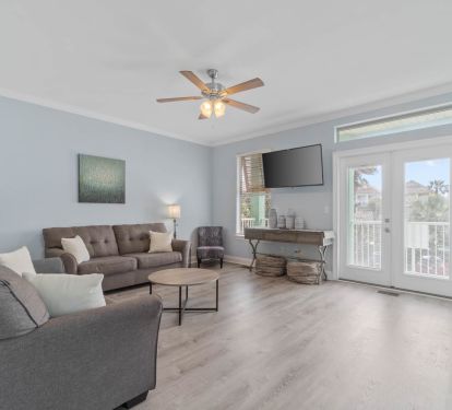 2nd floor living room with pull out queen bed, TV, and door to 2nd floor balcony