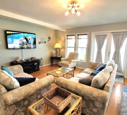Living room with seating for 6 and large screen smart TV and DVD player