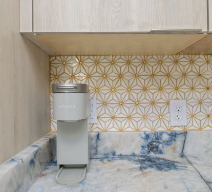 Shimmering gold accents in both the natural quartzite and tile backsplash