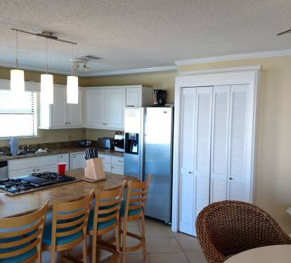 The light, airy kitchen is fully stocked with dishes, utensils, pots and pans.