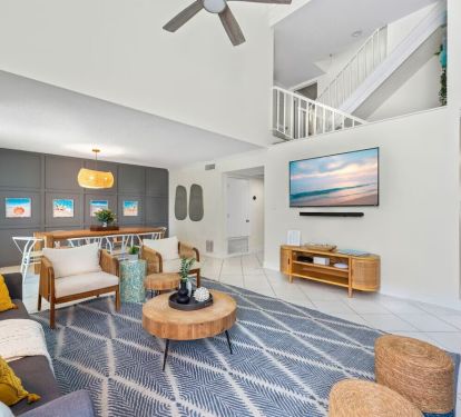 Cozy up at Seabreeze Villa ðŸ”¥ This inviting living room features a warm fireplace and coastal-inspired decor&mdash;perfect for relaxing after a day at the beach. Your seaside escape is just a booking away! ðŸŒ´âœ¨