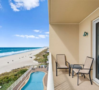 Private beachfront balcony overlooking resort pool, white sand beach, and Gulf views