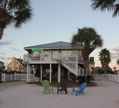 Lagoon side of the house showing rear deck, patio underneath and sandy back yard