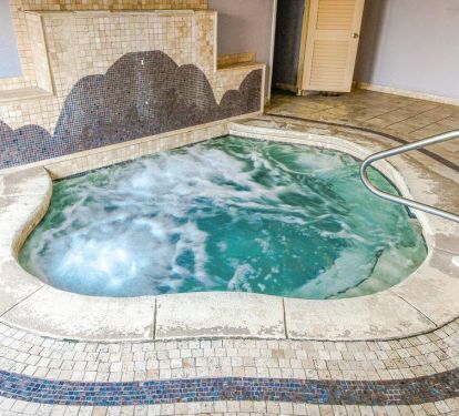 Large Indoor bubbly hot tub, located by the pool area.