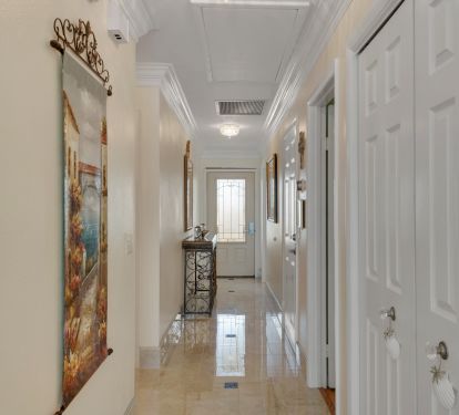 Hallway looking towards front door showing porcelain tile flooring