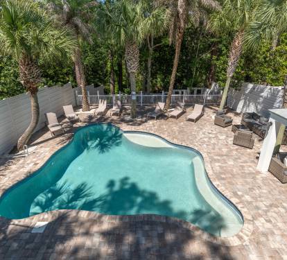 A large pool and expansive patio with room to lounge and covered seating.