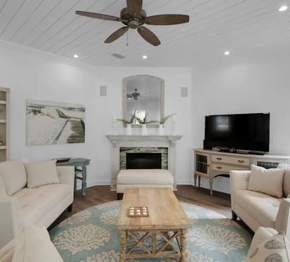 Vibe-23 Large comfortable living room with multiple seating options that opens to the dining and kitchen area and flows into the outdoor seating area. Designed to comfortably accommodate large groups with coastal chic flair.