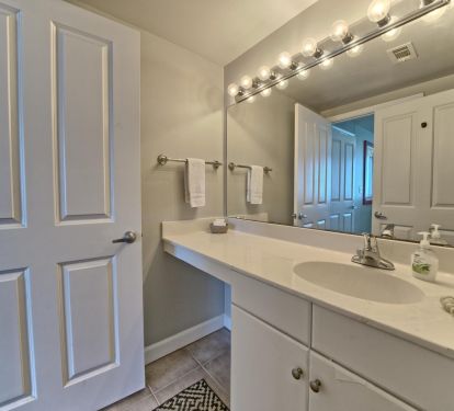 Master bath with vanity separated by door to shower, toilet. 