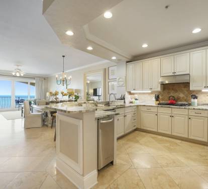 Elegant coastal style kitchen with oversized island and bar seating, granite countertops, and high end Viking appliances where you can cook delicious meals and dine while overlooking the Gulf!