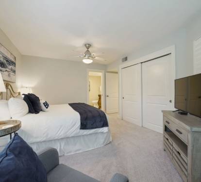 Enjoy modern comforts including a smart TV, bedside lighting, and serene coastal tones that create a restful vacation atmosphere.