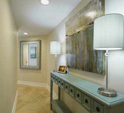 The thoughtfully decorated entryway offers a clean, airy feel with upscale finishes and beach-inspired accents.