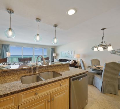 This open concept kitchen in our Destin beachfront condo features granite countertops, stainless appliances, and stunning Gulf views.