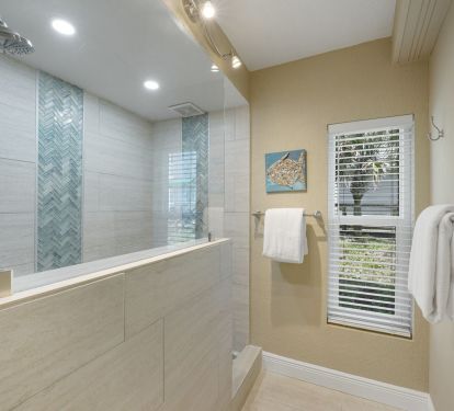 Modern vacation rental Master bath with large tiled shower, rainfall showerhead, and spa-inspired coastal finishes.