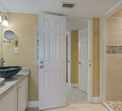 Updated guest bathroom featuring a modern glass vessel sink, marble style vanity, and spacious walk-in tiled shower.