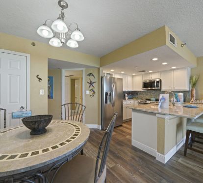 This bright and inviting vacation rental offers an open kitchen with stainless appliances, custom backsplash, and breakfast bar. The cozy dining space makes it easy to gather and enjoy meals together.