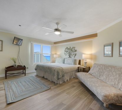 This bright beach-themed master bedroom offers comfortable furnishings, a flat-screen TV, and plenty of space to unwind during your Gulf-front getaway.