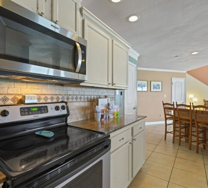 Open-concept coastal kitchen with bar seating and stainless steel appliances at Cabana Club 401.
