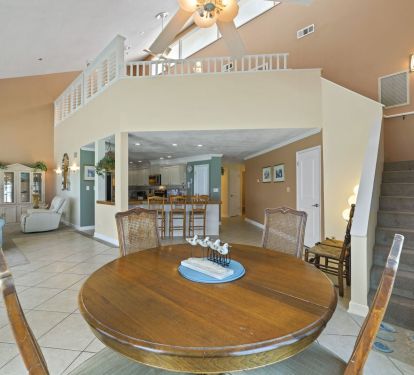 Spacious open-concept living area with soaring ceilings and loft overlooking dining space.