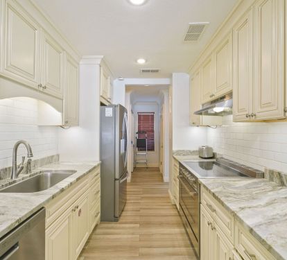 Start your morning in this bright coastal kitchen, brewing coffee as sunlight spills across marble countertops and plans for another perfect beach day begin.