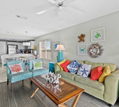 Open-concept living and dining area with vibrant coastal d-cor and plenty of natural light.